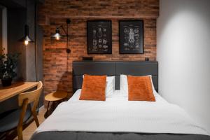 a bedroom with a bed with orange pillows and a desk at MYFREEDOM Апартаменти Братиславська 4 in Kyiv