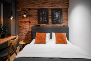 a bedroom with a bed with orange pillows and a desk at Апартаменти MYFREEDOM поруч із метро Чернігівська in Kyiv