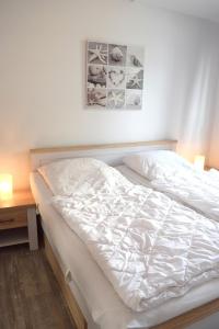 um quarto com uma cama branca e uma secretária em Ferienwohnung Steffens - "Wicheldorfstraße" em Grömitz