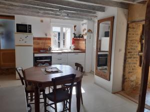a small kitchen with a wooden table and chairs at Le gîte des pierres in Nogent-le-Rotrou