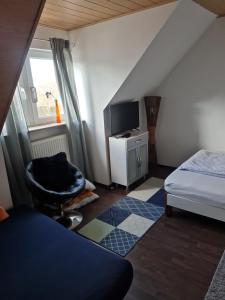 a bedroom with a bed and a chair and a tv at Ferienwohnung Bluhm Wahlstedt 