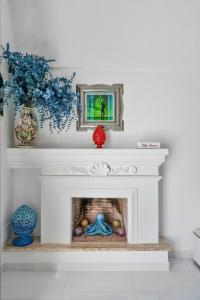 Villa Navarra في برايانو: مدفأة بيضاء في غرفة المعيشة مع مزهرية