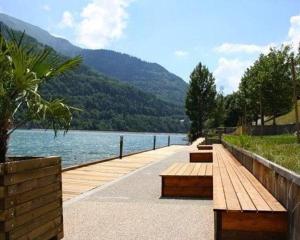 a row of benches next to a body of water at Appartement T3 Allemond in Allemont