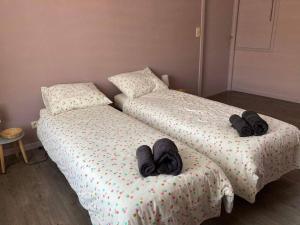 2 bedden met slippers in een slaapkamer bij Comme Che(z)Lui in Spa