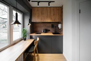 a kitchen with wooden cabinets and a wooden table at Апартаменти MYFREEDOM поруч із метро Чернігівська in Kyiv