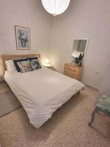 - une chambre avec un grand lit blanc et une commode dans l'établissement Ground floor apartment 3 min walk from the sea, à Marsaskala