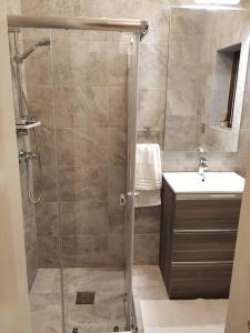 La salle de bains est pourvue d'une douche et d'un lavabo. dans l'établissement Ground floor apartment 3 min walk from the sea, à Marsaskala