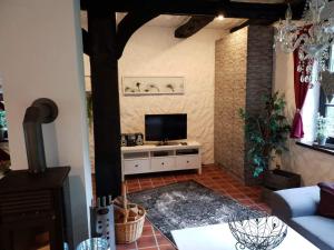 uma sala de estar com uma televisão na parede em Ferienhaus Oak-Tree-Cottage em Beverstedt