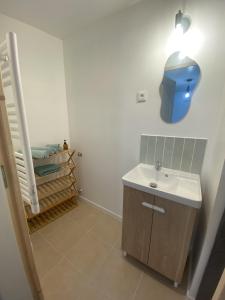 baño con lavabo y un objeto azul en la pared en Appartement confort, en Pacy-sur-Eure