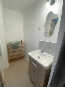 y baño con lavabo y espejo. en Appartement confort, en Pacy-sur-Eure