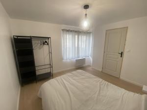 um quarto branco com uma cama e uma janela em Appartement confort em Pacy-sur-Eure