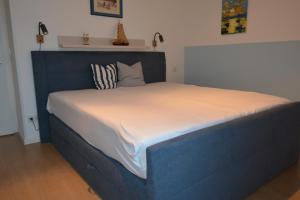 ein großes Bett mit blauem Rahmen in einem Schlafzimmer in der Unterkunft Residenz Kümpel in Balm