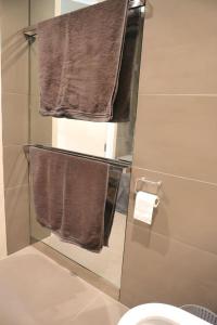 a bathroom with brown towels on a shower door at 2 Bedroom 2 Bathroom Apartment in Kings Cross Station in London