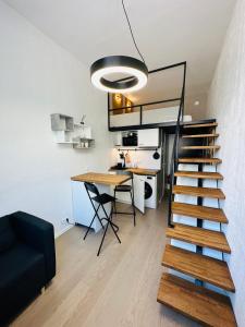 Cette chambre dispose d'un escalier, d'une table et d'un bureau. dans l'établissement City Apartments, à Tallinn