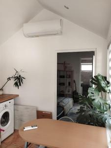 uma sala de estar com uma mesa e uma máquina de lavar roupa em Ibolya Apartman Debrecen kertvárosàban em Debrecen