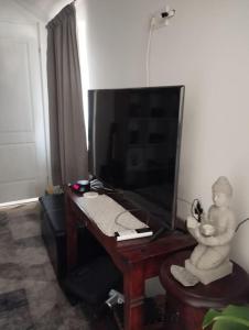 uma secretária com um monitor e uma estátua de um bebé em Ibolya Apartman Debrecen kertvárosàban em Debrecen