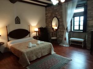 a bedroom with a bed and a table and a mirror at Palacio de Cantiz in Becerreá