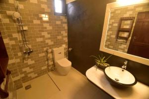 a bathroom with a white toilet and a sink at Hiru Lagoon Negombo in Negombo