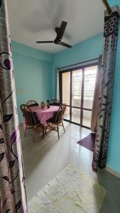 ein Esszimmer mit einem Tisch, Stühlen und einem Fenster in der Unterkunft SheStay - Homestay by Women, for Women in Thākurdwari