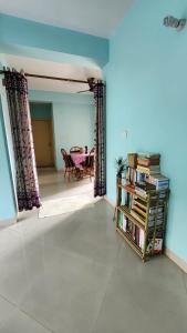 ein Wohnzimmer mit einem Tisch und einem Bücherregal in der Unterkunft SheStay - Homestay by Women, for Women in Thākurdwari