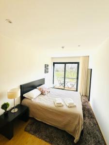 a bedroom with a bed with two pillows and a window at Casa do Carvalho - Ponte de Lima in Ponte de Lima