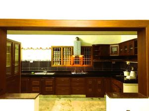 a kitchen with wooden cabinets and a large window at Golden Gate Serviced Apartment in Chennai