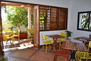 eine Terrasse mit gelben Stühlen und Tischen in einem Restaurant in der Unterkunft Kily House in Morondava
