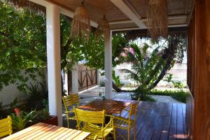 a porch with a wooden table and yellow chairs at Kily House in Morondava