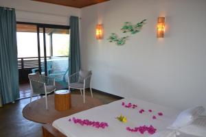 a bedroom with a bed with pink flowers on it at Kily House in Morondava