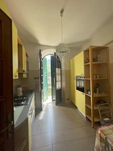 una cocina con armarios amarillos y un pasillo con en A casa di Atti, en Biassa