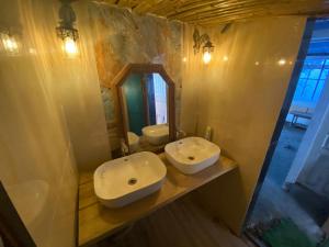 a bathroom with two sinks and a mirror at Himalayan Hideaway-TVM in Manāli