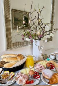 einen Tisch mit Frühstückszutaten und eine Vase mit Blumen in der Unterkunft Pension Phoenix in Znojmo