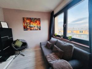 ein Wohnzimmer mit einem Sofa und einem großen Fenster in der Unterkunft Apartment Wien - Near Schönbrunn Palace in Wien