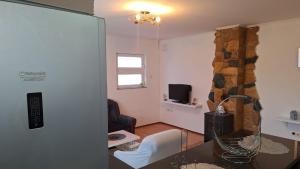 a living room with a table and a chair and a television at Apartman Porfido in Mostar