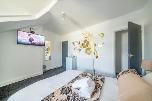 a bedroom with a bed and a tv on the wall at *RA246* For your most relaxed & Cosy stay + Free Parking + Free Fast WiFi * in Knowsthorpe