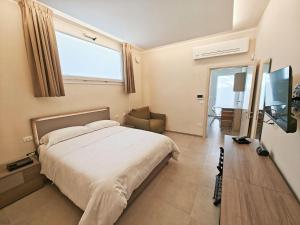 a bedroom with a large bed and a television at A casa di Nina in Leverano