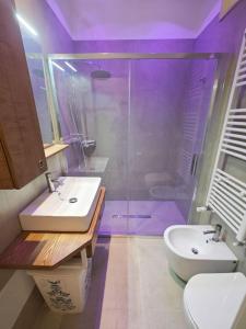un bagno viola con lavandino e doccia di A casa di Nina a Leverano