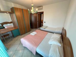 a bedroom with two beds and a chandelier at Residence Diana Frontemare - Agenzia Cocal in Caorle