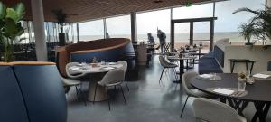 een restaurant met tafels en stoelen en uitzicht op het strand bij Beachstudio Westende with sea view in Middelkerke