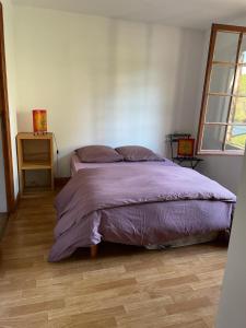 A bed or beds in a room at Appartement au fond du jardin