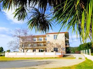 un edificio con una palmera delante en Hotel Campestre Chamuiñas, en Sanxenxo
