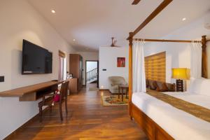 a bedroom with a bed and a tv on a wall at The Isle By Area 707 in Alwaye