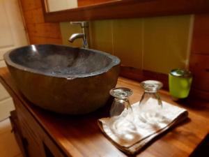 un bol en métal sur un comptoir en bois avec deux bouteilles en verre dans l'établissement Chalet Chaleureux, à La Plaine-des-Palmistes