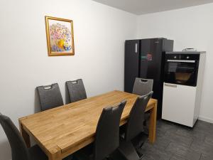 a dining room with a wooden table and a refrigerator at Ferienwohnung Schneider in Bad Wildungen +2 photos