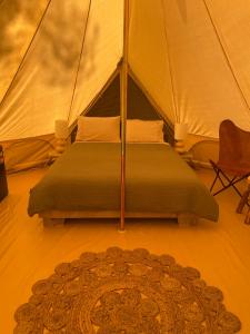 a bedroom with a bed in a tent with a rug at Camp Crusty Eldorado in Eldorado