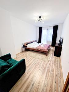 een woonkamer met een bed en een bank bij Apartment Tatry Hiking & Wellness in Veľká Lomnica