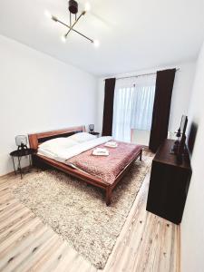 een slaapkamer met een bed, een dressoir en een tafel bij Apartment Tatry Hiking & Wellness in Veľká Lomnica
