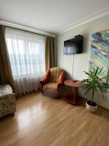 ein Wohnzimmer mit einem Stuhl und einem Tisch in der Unterkunft Готель Алекс in Luzk