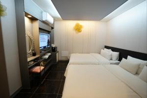 a hotel room with two beds and a television at Shinchon Y Hotel in Seoul