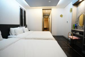 a hotel room with two beds and a chair at Shinchon Y Hotel in Seoul